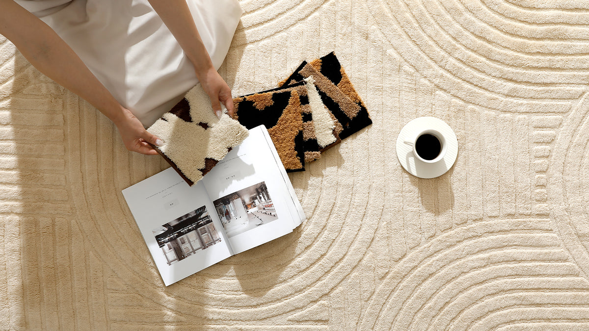 Plush rug swatches displayed on a cream textured YIHOUSE area rug beside a book and coffee.