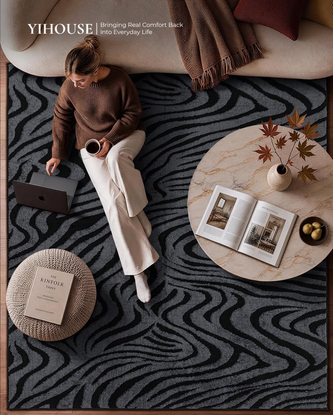 Woman relaxing with a laptop on a black and gray zebra-pattern YIHOUSE area rug.
